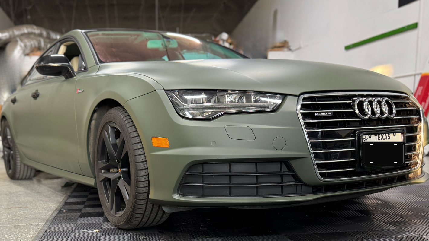 Green Audi car in a garage with checkered floor
